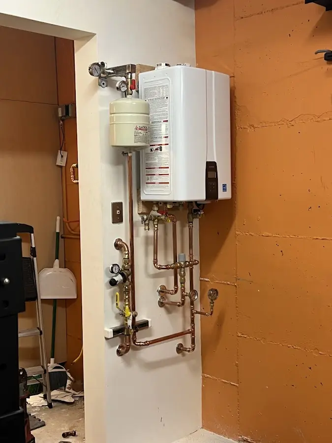 Plumbing technician inspecting water heater connections in Waxhaw